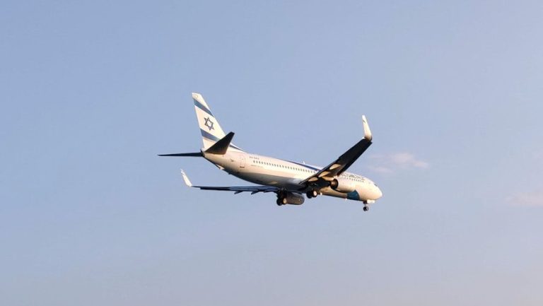 white and black Israeli airplane flying over the sea during daytime