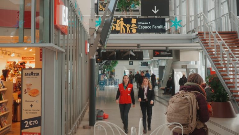 People walk through a modern indoor shopping center.