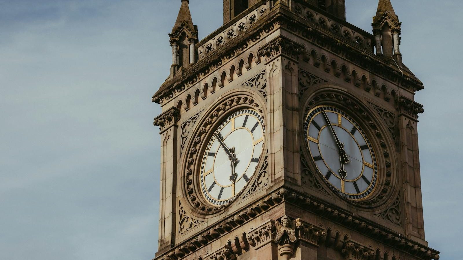 Close-up of the Albert Memorial Clock Tower in Belfast, showcasing intricate architectural details under a clear sky.