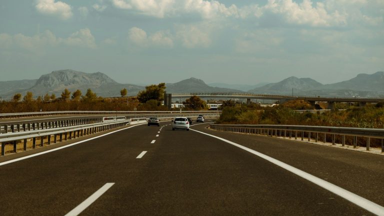 A car driving down a highway with mountains in the background
